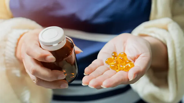 Woman over 50 checking label on supplements for perimenopause bottle