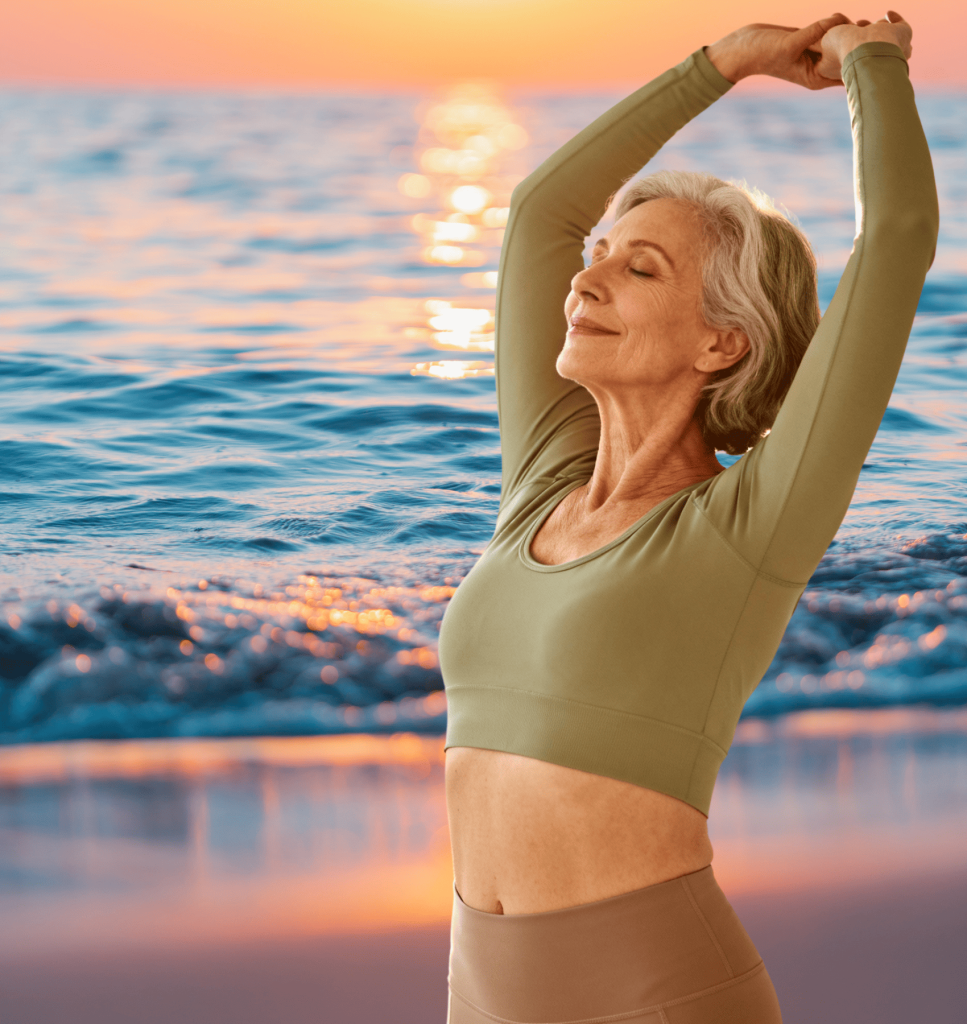 Woman over 50 stretching pain-free at sunrise after using supplements for menopause joint pain relief