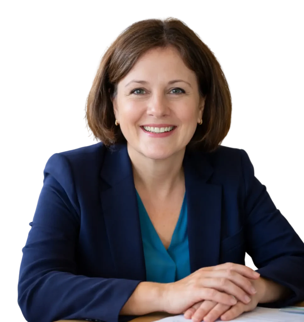 Professional woman with brunette hair wearing a green blouse, smiling gently and posing confidently.