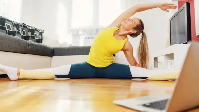 Strength training for women 50 woman in her 50s doing a squat at home to build strength and confidence.