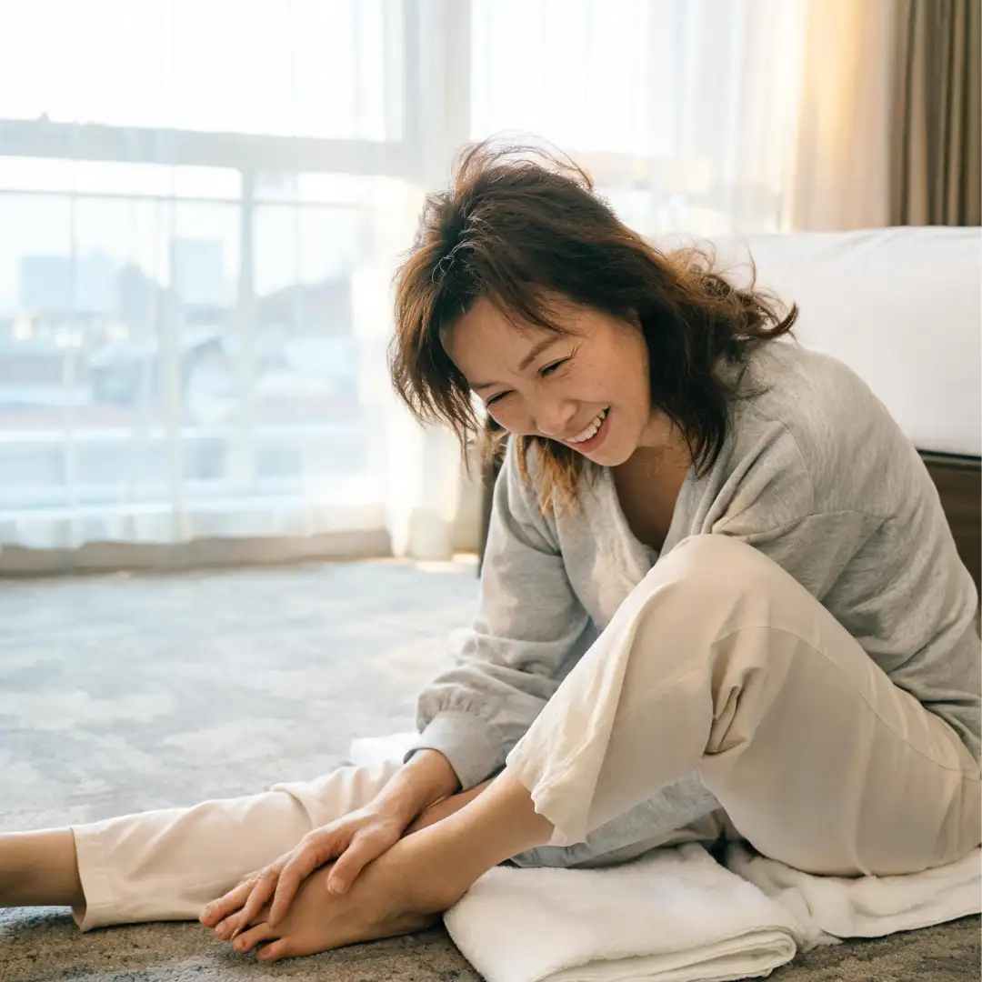 Travel after 50 : A real woman over 50 doing a gentle morning stretch in a hotel room building her daily movement routine